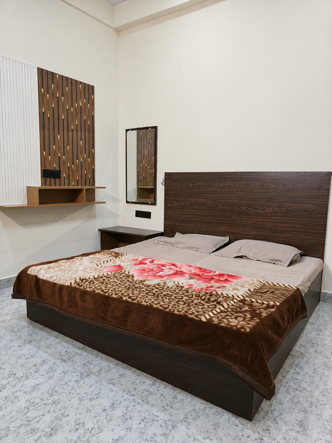 Standard double bedroom at Your Choice Homestay with a wooden headboard and floral blanket